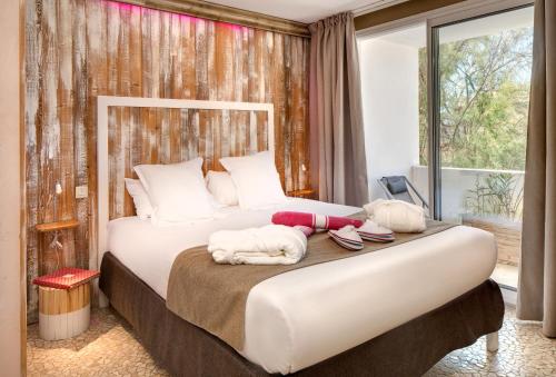 a bedroom with a large bed with towels on it at Vila De La Mar & Spa in Saintes-Maries-de-la-Mer
