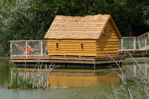a wooden house on a dock in the water at Les Cabanes Flottantes in Givrauval