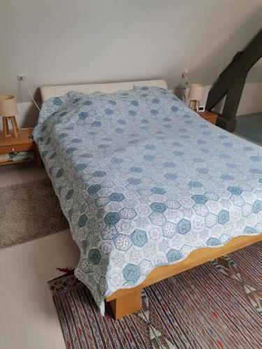 a bedroom with a bed with a blue quilt on it at La dépendance, petite maison au calme 1Chambre in Vallon-sur-Gée