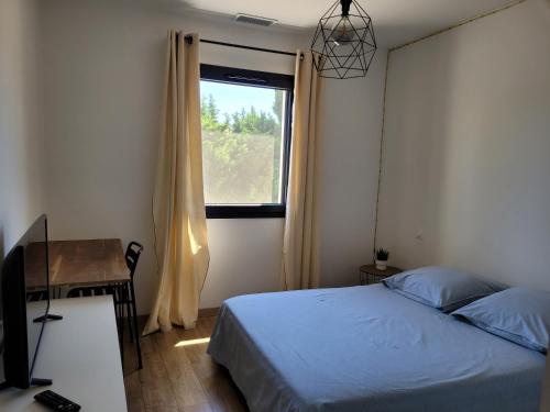 um quarto com uma cama, uma secretária e uma janela em Maison Gioia em Châteaurenard