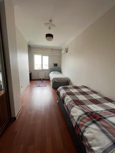 1 Schlafzimmer mit 2 Betten und Holzboden in der Unterkunft Akkoza Koru Bloklari in Esenyurt