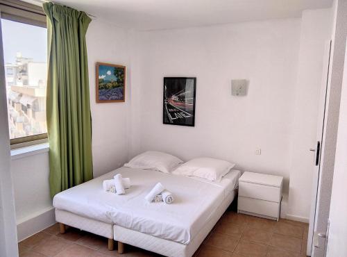 Résidence Graziella Appartement 627 في خوان ليس بينس: غرفة نوم بسرير وملاءات بيضاء ونافذة