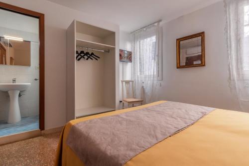 a bedroom with a bed and a sink and a bathroom at Hotel Casa Boccassini in Venice