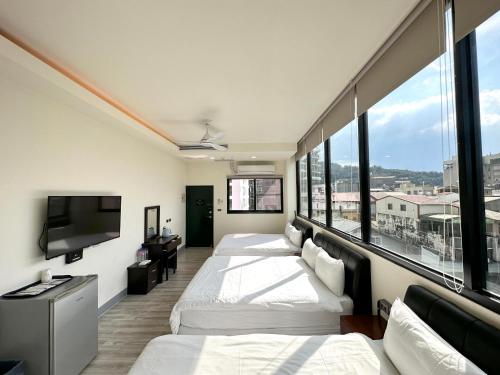 a hotel room with two beds and a flat screen tv at Zhen House 珍棧民宿 in Yuchi