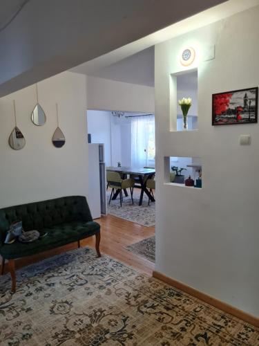 a living room with a green couch and a table at Apartament Central in Gherla