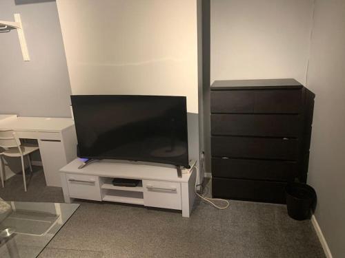 a flat screen tv sitting on top of a white cabinet at Superb 4 Bed 4 Bath House Right by Luton Airport in Luton