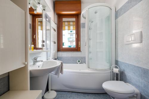 a bathroom with a tub and a sink and a toilet at Cosy Studio with balcony & private garage in Milan