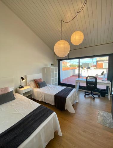 a bedroom with two beds and a chair and lights at Casa centro Sabadell a 20Km de Barcelona ideal Familias y Grupo Amigos in Sabadell