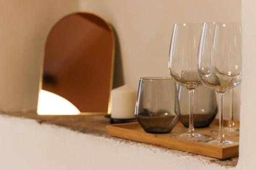 drei Weingläser auf einem Tisch neben einem Spiegel in der Unterkunft Charming Jerusalem Home in Jerusalem