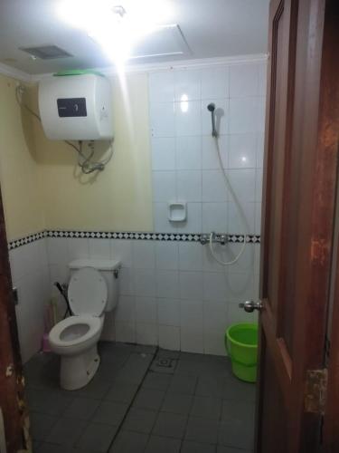 uma casa de banho com um WC e um chuveiro com luz em Hotel Lippo Carita em Pandegelang