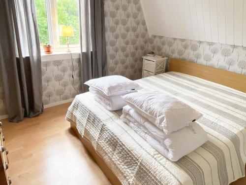 1 dormitorio con 1 cama con sábanas y almohadas blancas en Holiday home VÄSTRA ÄMTERVIK, en Östra Ämtervik