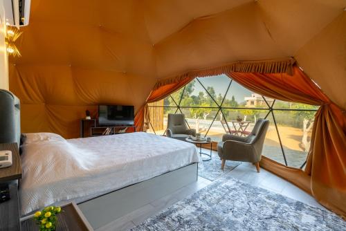 ein Schlafzimmer mit einem Bett in einem Zelt in der Unterkunft Yeşilçam Glamping in Çakırlar