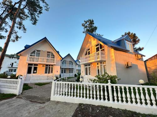 a row of houses with a white fence at Cottage Tbiliselebi in Ureki