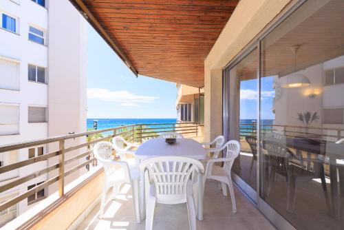 a balcony with a table and chairs and the ocean at UHC Capote Family Apartments in Salou