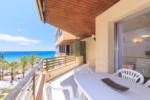 a balcony with a table and chairs and the beach at UHC Capote Family Apartments in Salou