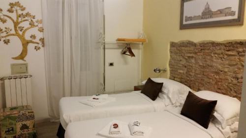 ローマにあるナヴォーナ ファースト ルームのベッド2台とソファが備わるホテルルームです。