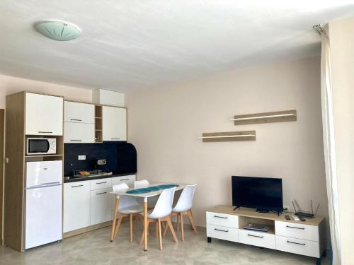 een kleine keuken met een tafel en stoelen in een kamer bij Apartments in Villas Apolon in Sozopol