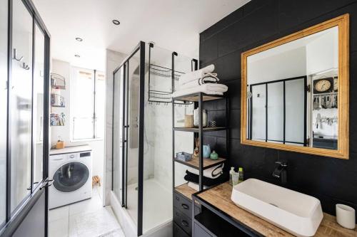 a bathroom with a sink and a shower and a mirror at Charmant Appartement avec Jardin in Suresnes