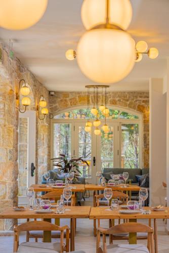 a dining room with wooden tables and chandeliers at Kairos Valley Wellness & Longevity in Datca