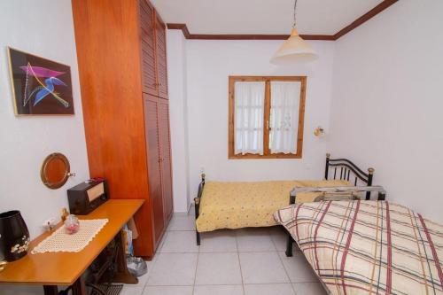 niewielka sypialnia z łóżkiem, stołem i biurkiem w obiekcie Zen house w mieście Potistika