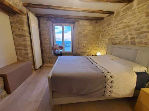 1 dormitorio con 1 cama con pared de piedra en Le Paradis de Nina 