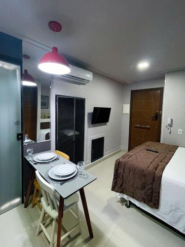 a room with a bed and a table with plates on it at Studio Bangalô Belém Hospedagem in Belém