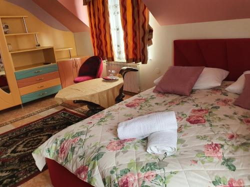 a bedroom with a bed with a floral bedspread and a table at Flamingo 