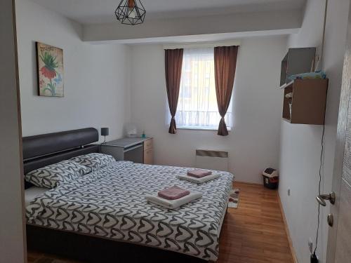 um pequeno quarto com uma cama e uma janela em Apartman Park em Zvornik