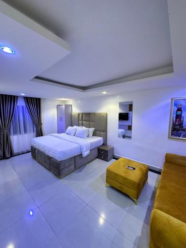 Primal Msquare Apartment Ikoyi في لاغوس: غرفة نوم كبيرة مع سرير وأريكة