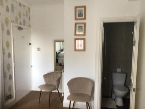 uma sala de estar com 2 cadeiras e um WC em Seacrest Guest House Room Only em Whitby