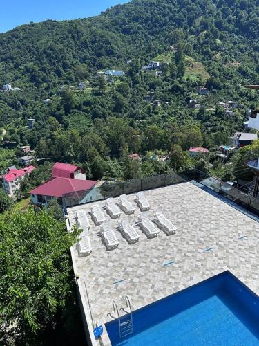 a swimming pool with lounge chairs on top of a building at Goga Guest House in Kvariati