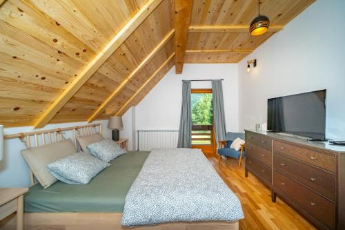 a bedroom with a bed and a flat screen tv at House Andrija in Jasenak