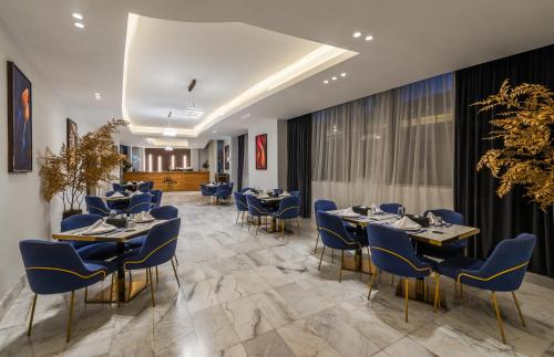 une salle à manger avec des tables et des chaises bleues dans l'établissement Hadab Al Sahafa, à Riyad