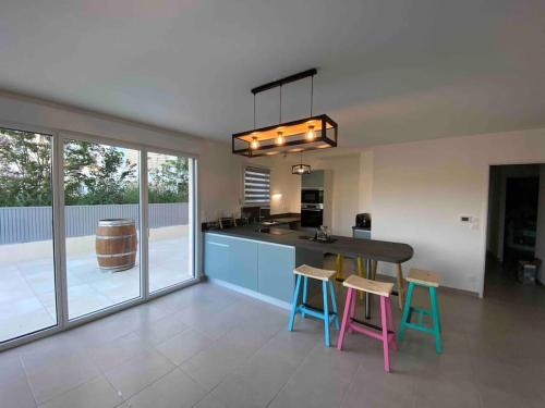 une cuisine avec une table et des tabourets dans une pièce dans l'établissement Superbe appartement T3 centre ville Rondelet, à Montpellier