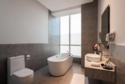 La salle de bains est pourvue d'une baignoire, de toilettes et d'un lavabo. dans l'établissement Hadab Al Sahafa, à Riyad