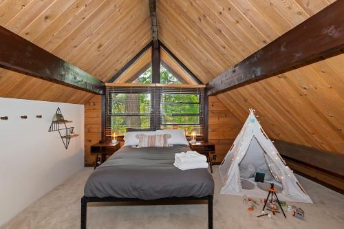 大熊湖的住宿－New!!! Dreamy Bear Haus- Updated Retro Retreat & Spa, Pet & Kid Friendly，一间带一张床的卧室,位于带木制天花板的房间内