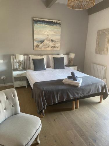 ein Schlafzimmer mit einem großen Bett und einem Stuhl in der Unterkunft appartement a 50 m de la place aux herbes in Uzès