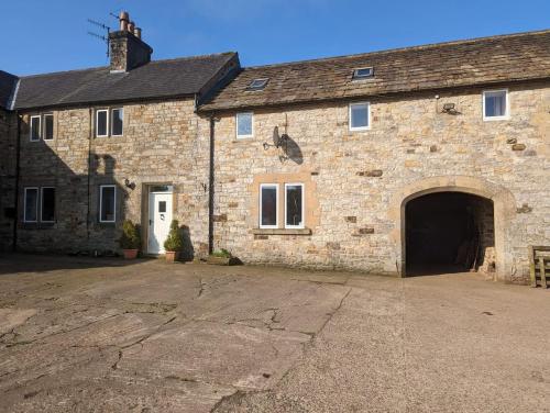 an old stone building with a large garage at The cottage in Alston