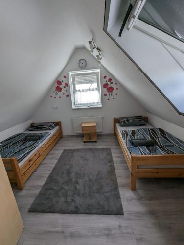 a attic room with two beds and a window at MO-ZI-LA in Oberlangfurth