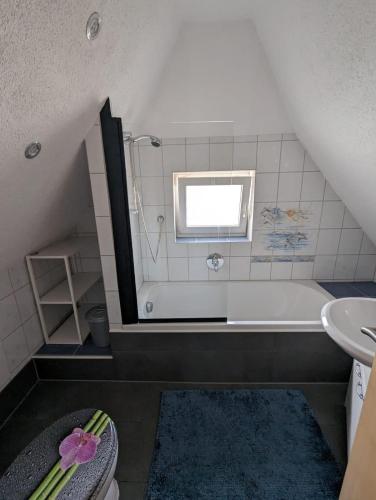a bathroom with a bath tub and a sink at MO-ZI-LA in Oberlangfurth