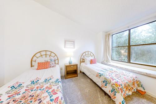 American BeachにあるTwo-story townhome with fast WiFi & pool - steps from the beachの窓のある寝室にベッドが2つある