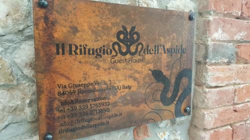 a sign attached to a brick wall with a ticket at Il Rifugio dell'Aspide in Roccadaspide