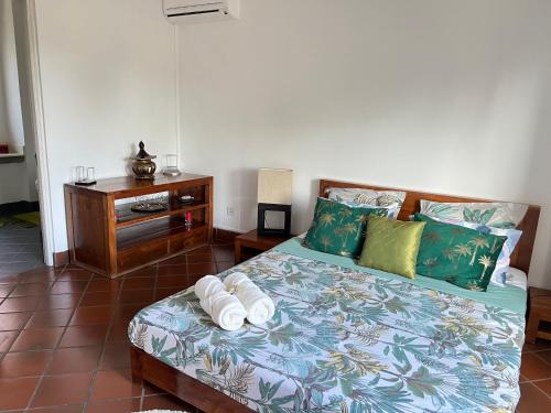 a bedroom with a bed with pillows and a table at Cozy one bedroom apartment in a secure complex , PORT CHAMBLY Mauritius in Terre Rouge