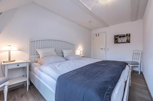Habitación blanca con cama grande y escritorio. en fewo1846 - Im Sonnenhof - komfortable 2-Zimmer-Wohnung im Stadtzentrum, en Flensburg