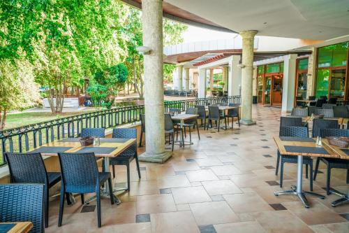 a restaurant with tables and chairs and a fence at Calimera Ralitsa Superior Hotel - Ultra All Inclusive plus Aquapark in Albena