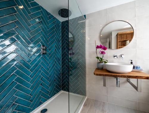 uma casa de banho com uma banheira, um lavatório e um espelho. em Blackberry Cottage - Newly renovated cosy cottage em Malborough