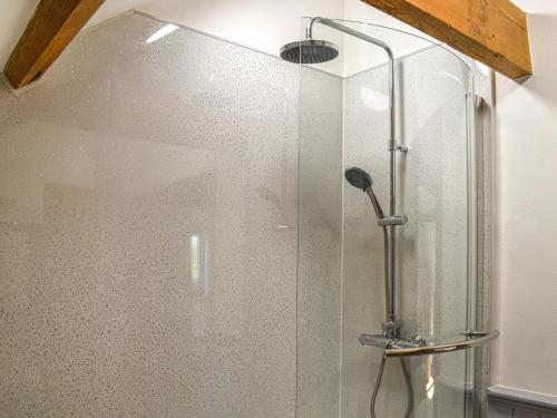 a shower with a glass door in a bathroom at Oak Barn in Felbrigg