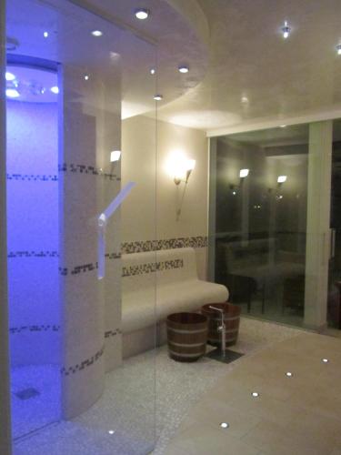 a bathroom with a glass shower with a bench at Hotel Sonnenhügel in Bad Bevensen