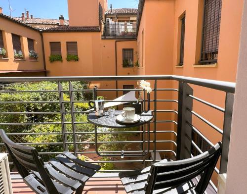 a balcony with two chairs and a table on a balcony at Alfea Suite in Bologna