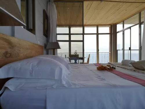 sypialnia z łóżkiem i widokiem na ocean w obiekcie Mawo house w mieście SantʼAna